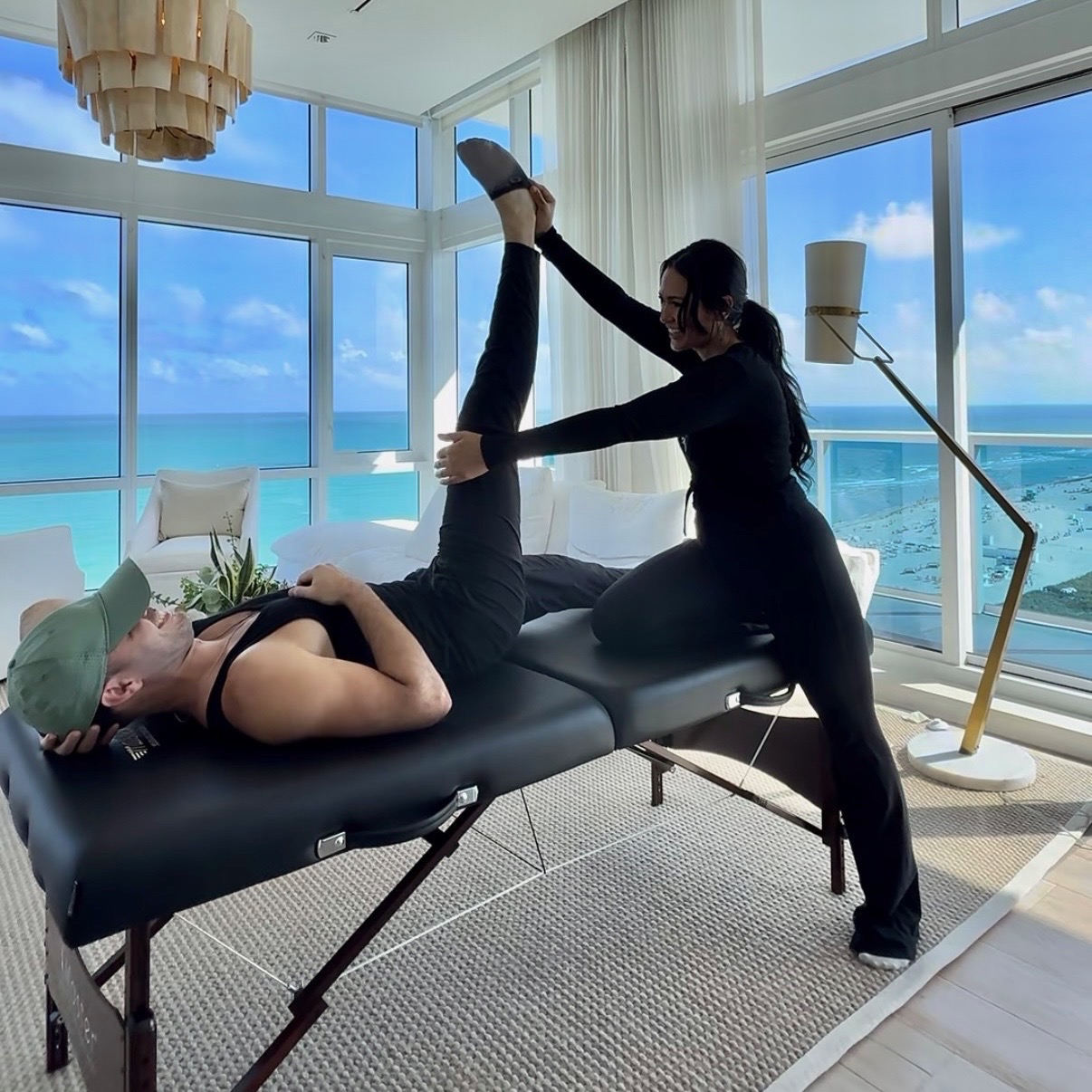 Stretch Space Miami specialist guiding a client through an assisted stretch with ocean views